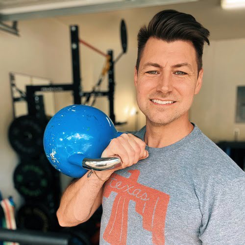 Smiling personal trainer holding a blue kettlebell in a gym setting, showcasing strength training and fitness expertise for personalized wellness programs.